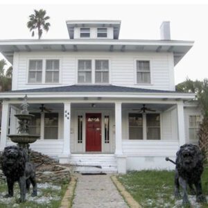 A big white house with a pair of lion statues in front